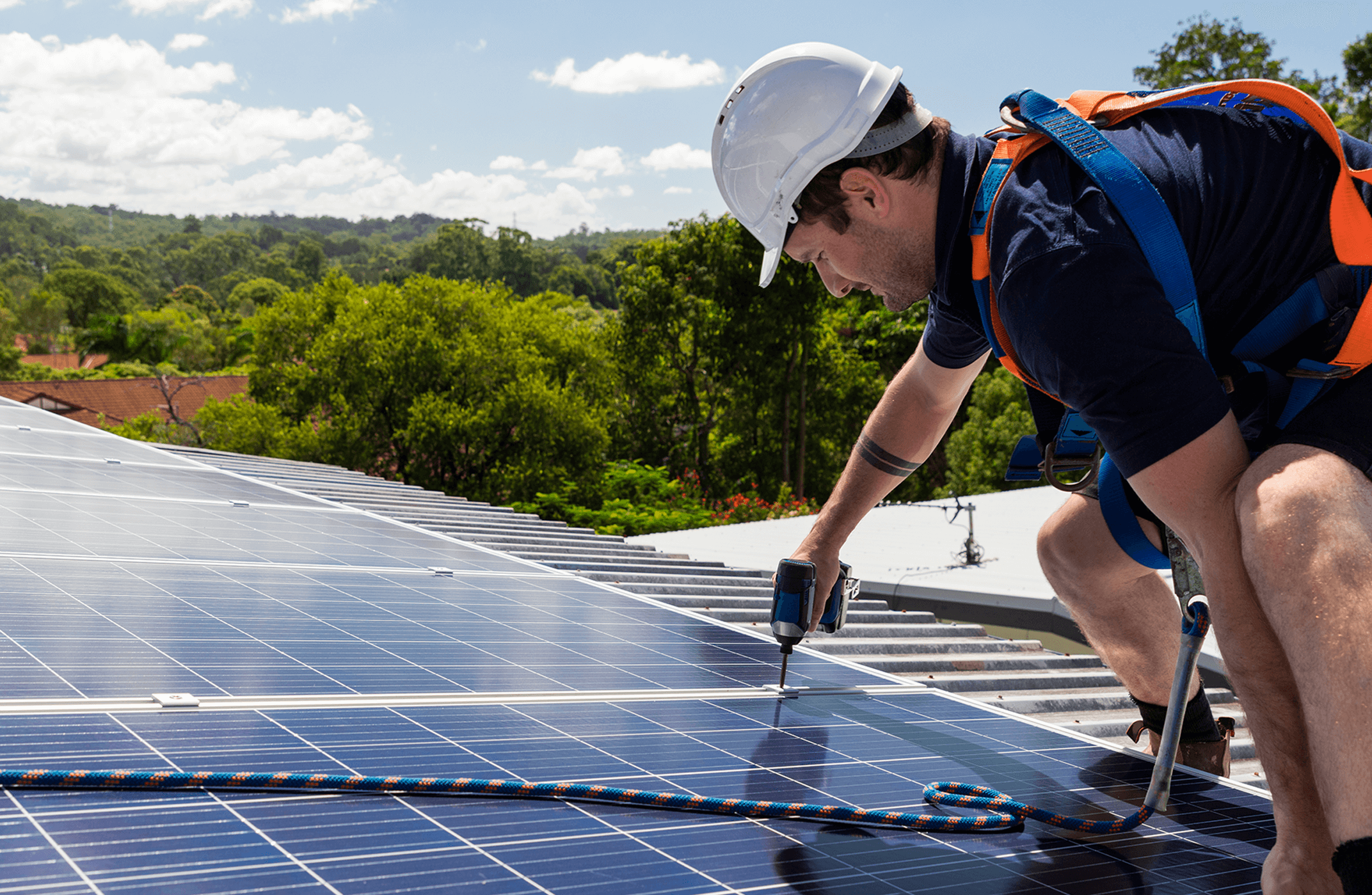 Man on roof installing solar panel
